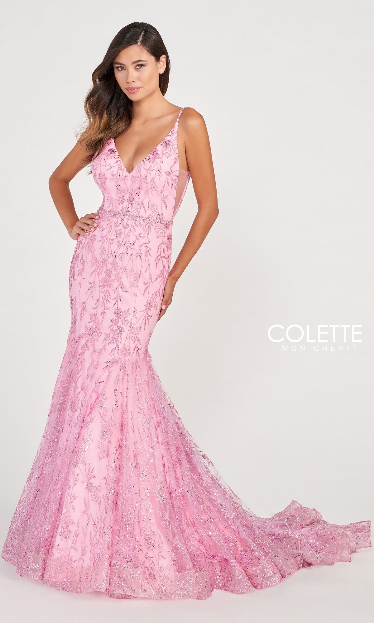 A woman poses with one hand on her hip against a plain backdrop in the Colette CL2021 Long Mermaid Glitter Prom Dress, a floor-length, fitted gown featuring sparkling details.